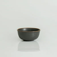 A 7-inch round ceramic bowl with a swirl pattern, primarily black in color with a light brown rim.