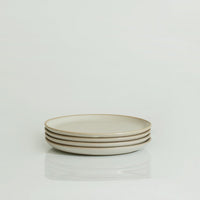 A stack of three white ceramic plates with a minimalistic open rim on a white background.
