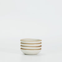 A set of four white ceramic sauce dishes with a matte finish and speckled peppering design, displayed against a plain background.