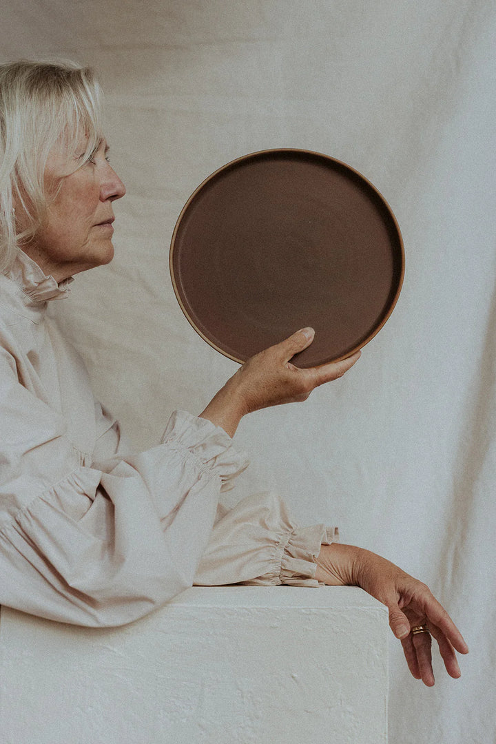Woman holding a lineage ceramics plate